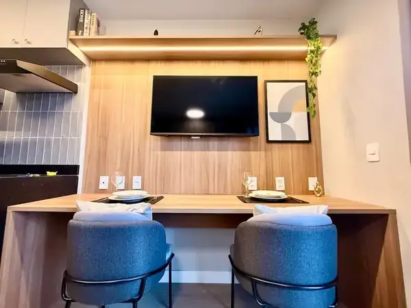 Bancada de refeição com painel de madeira e TV